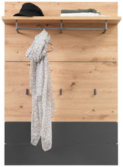 Garderobenpaneel aus Holz mit Haken und Ablage, frontal fotografiert. Auf der Ablage liegen ein Hut und gefaltete Kleidung, an einem Haken hängt ein gemustertes Tuch.