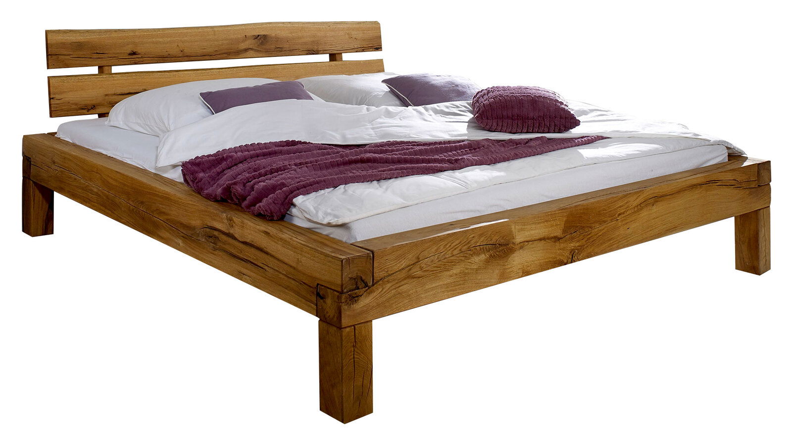Holzbalkenbett mit natürlicher Holzmaserung, seitliche Perspektive, mit weißer Bettwäsche und lila Kissen dekoriert.