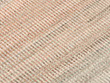 Nahaufnahme eines Designer Teppichs mit diagonalen Streifen in Beige- und Rottönen.