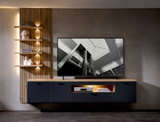 Moderne Wohnzimmerwand mit hängendem TV-Schrank und Holzregalen, seitliche Perspektive.