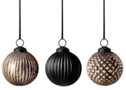 Drei kugelförmige Weihnachtsanhänger aus Glas in Gold und Schwarz mit geriffelter und genoppter Struktur, frontal vor weißem Hintergrund präsentiert