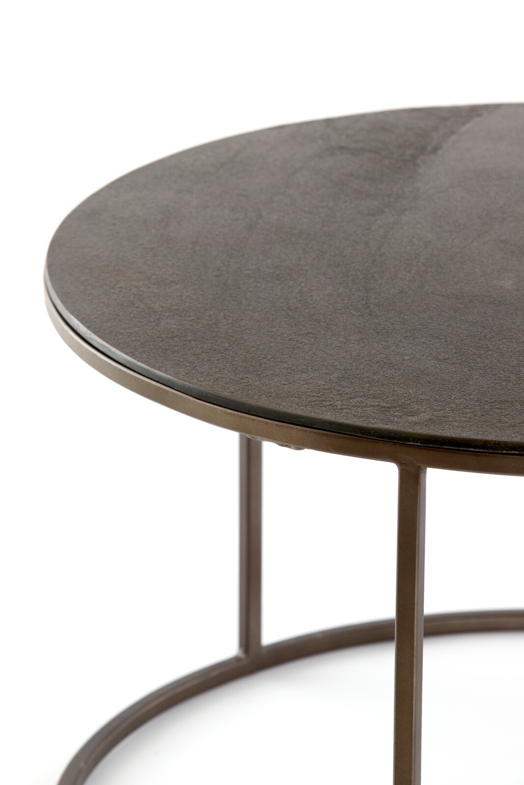 Close-up van een ronde salontafel met een donker tafelblad en een metalen onderstel, gezien vanaf de zijkant.