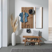Garderoben-Set mit Holzpaneel, Spiegel und Bank, frontal fotografiert. Dekoriert mit Hüten, Jacke, Tasche und Schuhen.