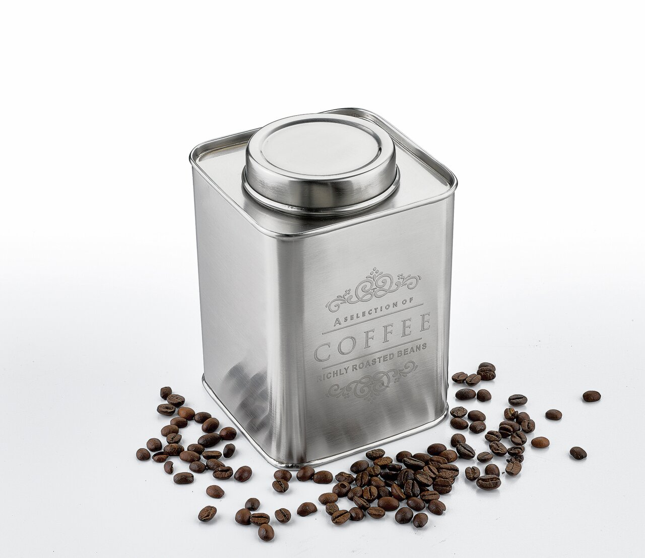 Silberne Vorratsdose für Kaffee mit Deckel, umgeben von Kaffeebohnen, aus leicht erhöhter Perspektive fotografiert.