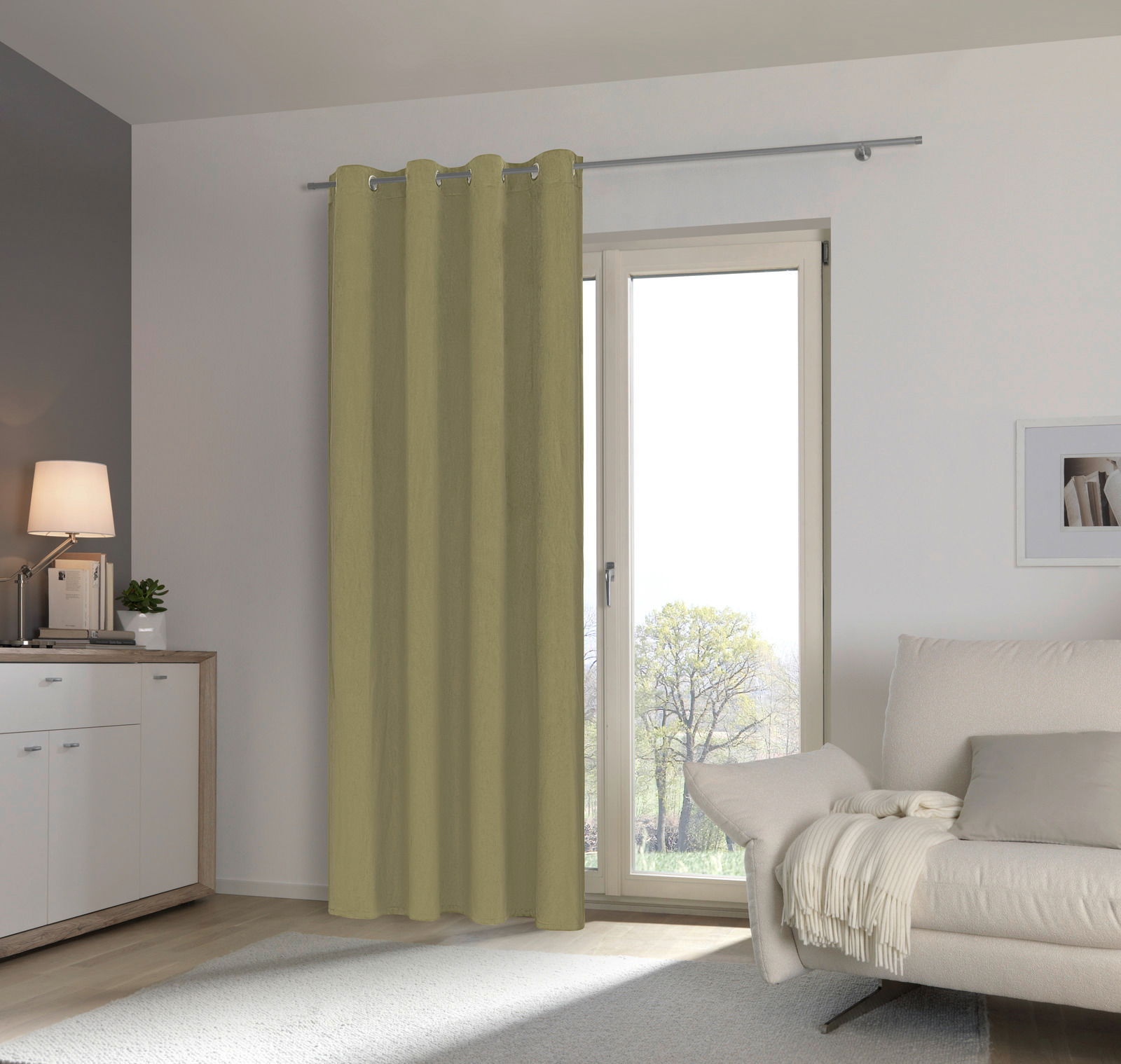 Grüner Ösenschal vor einem Fenster in einem modernen Wohnzimmer, seitliche Perspektive