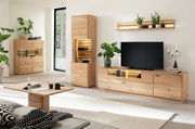 Modernes Highboard aus Holz in einem stilvoll eingerichteten Wohnzimmer, frontal betrachtet. Das Highboard hat eine Glasvitrine mit Beleuchtung und bietet Platz für Dekorationen und Bücher.