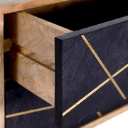 Nahaufnahme einer geöffneten Schublade einer Nachtkommode mit schwarzer Front und goldenen Linien, seitliche Perspektive.