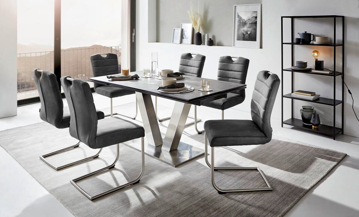 Moderner Esstisch mit sechs grauen Stühlen in einem hellen Raum, seitliche Perspektive