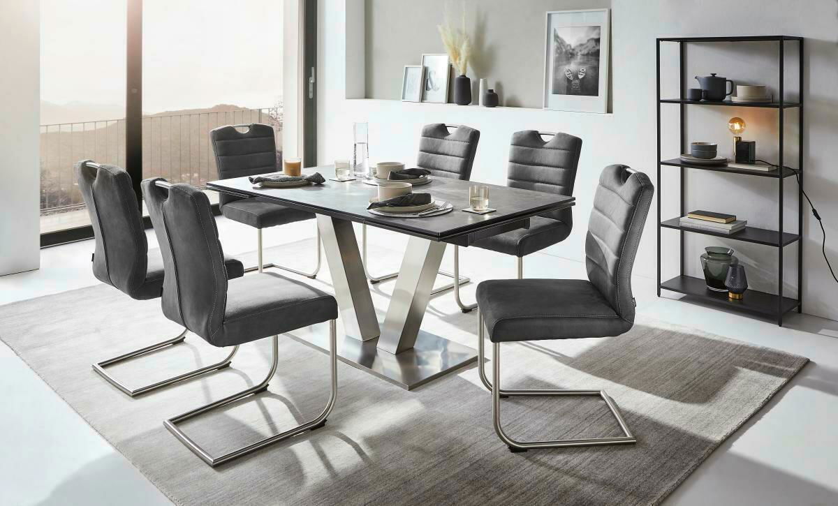 Moderner Esstisch mit sechs grauen Stühlen in einem hellen Raum, seitliche Perspektive