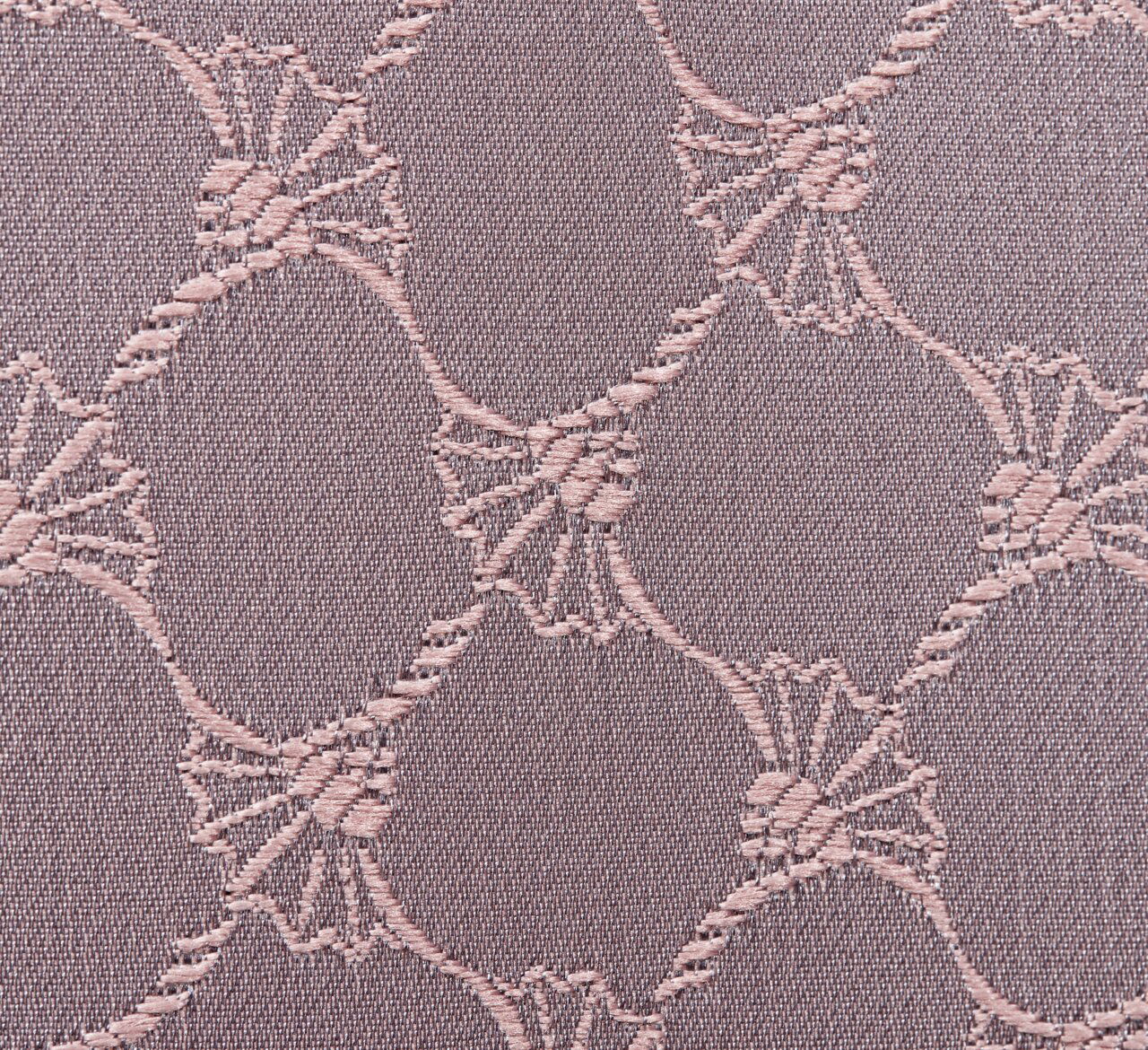 Nahaufnahme eines Stoffes mit einem eleganten, kreisförmigen Muster in Nude-Tönen.