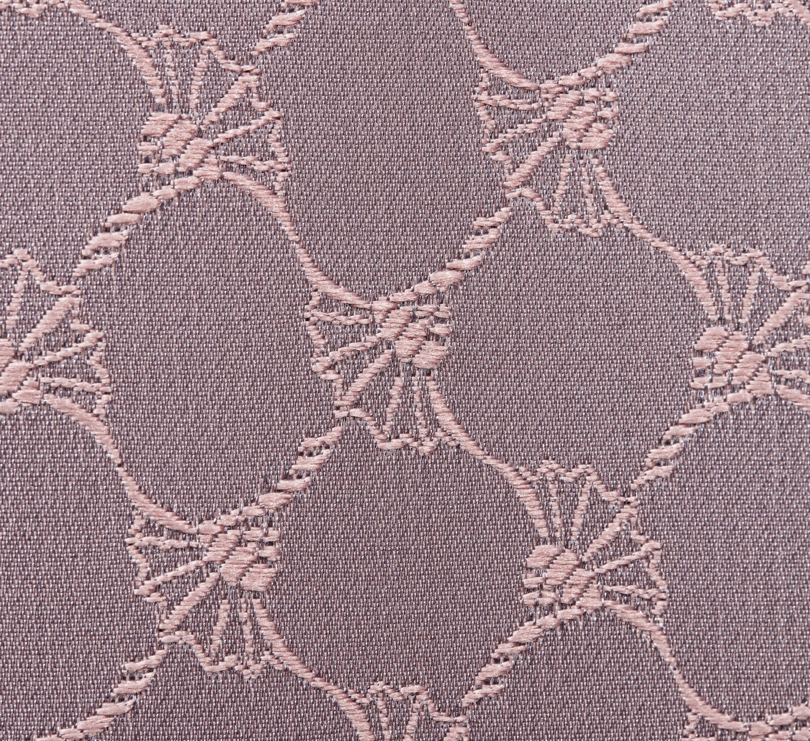 Nahaufnahme eines Stoffes mit einem eleganten, kreisförmigen Muster in Nude-Tönen.