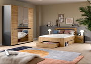 Modernes Schlafzimmer-Set in Eiche-Optik mit Bett inklusive ausziehbarem Bettkasten, Nachttisch und Kleiderschrank mit Spiegeltüren, gezeigt in schräger Frontansicht im eingerichteten Raum.