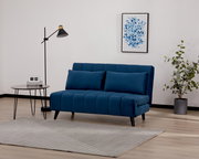 Blaues Funktionssofa in modernem Wohnzimmer, seitliche Perspektive, mit Stehlampe, Beistelltisch und Pflanzen.