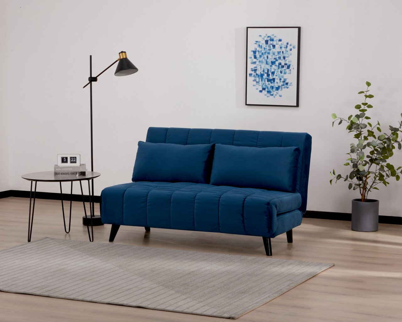 Blaues Funktionssofa in modernem Wohnzimmer, seitliche Perspektive, mit Stehlampe, Beistelltisch und Pflanzen.