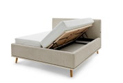 Zijaanzicht van een gestoffeerd bed met opgeklapt matras en zichtbare opbergruimte eronder.