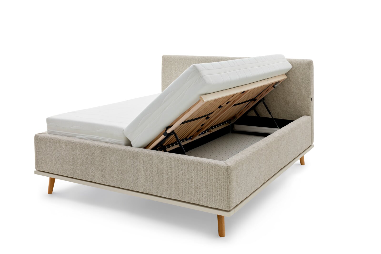 Zijaanzicht van een gestoffeerd bed met opgeklapt matras en zichtbare opbergruimte eronder.