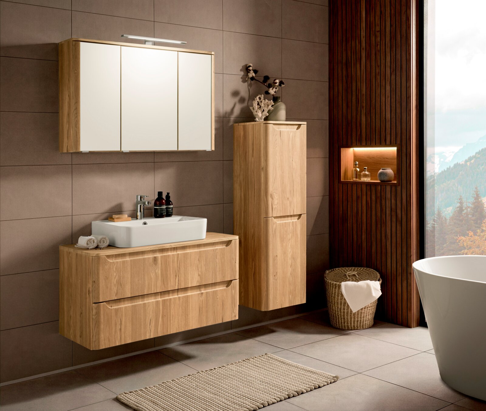 Modernes Badezimmer-Set in Holzoptik mit hängendem Waschtischunterschrank, weißem Aufsatzwaschbecken, Spiegelschrank mit LED-Leuchte und hohem Hängeschrank; Perspektive: Frontansicht leicht schräg von links.