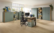 Moderne Büroeinrichtung mit Schreibtisch, Bürostuhl und mehreren Schränken in einem hellen Raum, seitliche Perspektive.