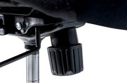 Nahaufnahme der Unterseite eines Drehstuhls mit Fokus auf den Mechanismus und Einstellknopf.