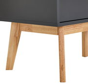 Nahaufnahme eines Highboards mit dunkler Oberfläche und hellen Holzbeinen, seitliche Perspektive