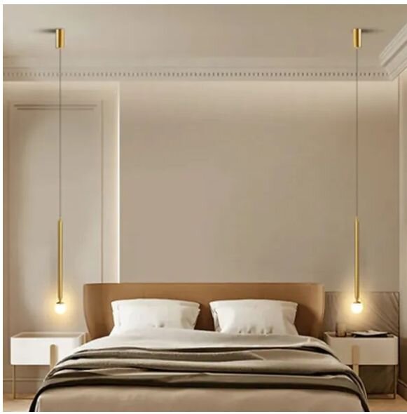 Modernes Schlafzimmer mit Doppelbett und zwei schlanken goldfarbenen Pendelleuchten neben dem Kopfteil, frontale Perspektive.