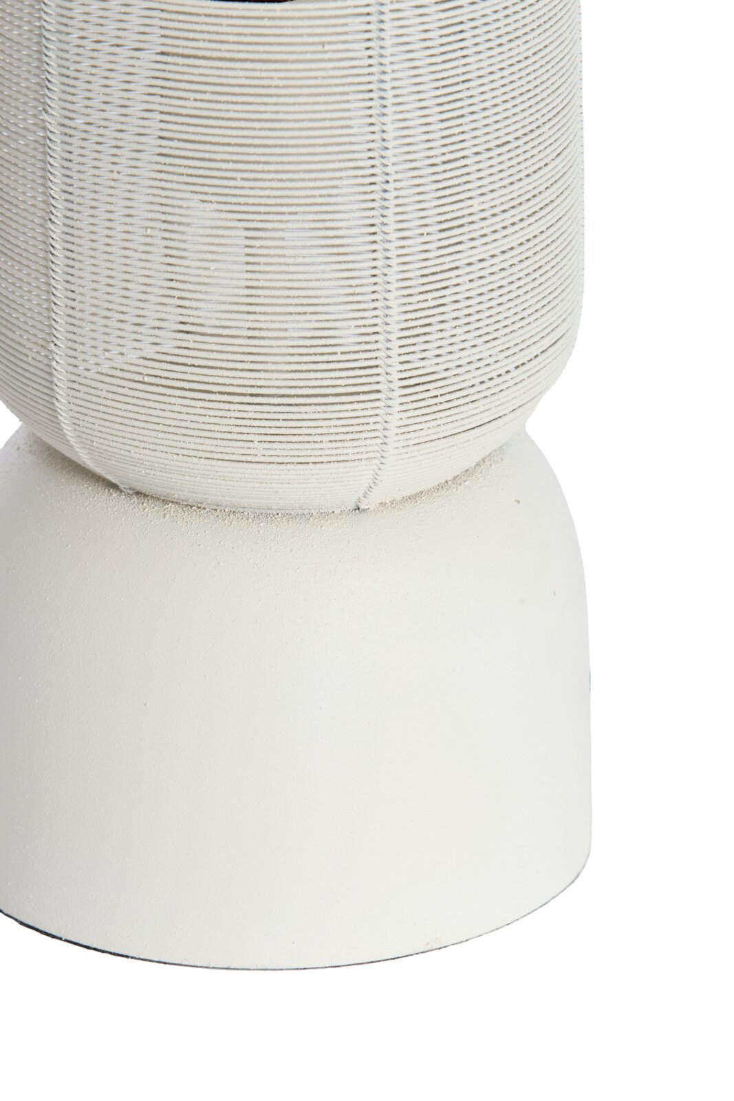 Close-up in vooraanzicht van een witte decoratieve vaas met een fijn geribbelde, bolle bovenzijde en een gladde cilindrische voet.