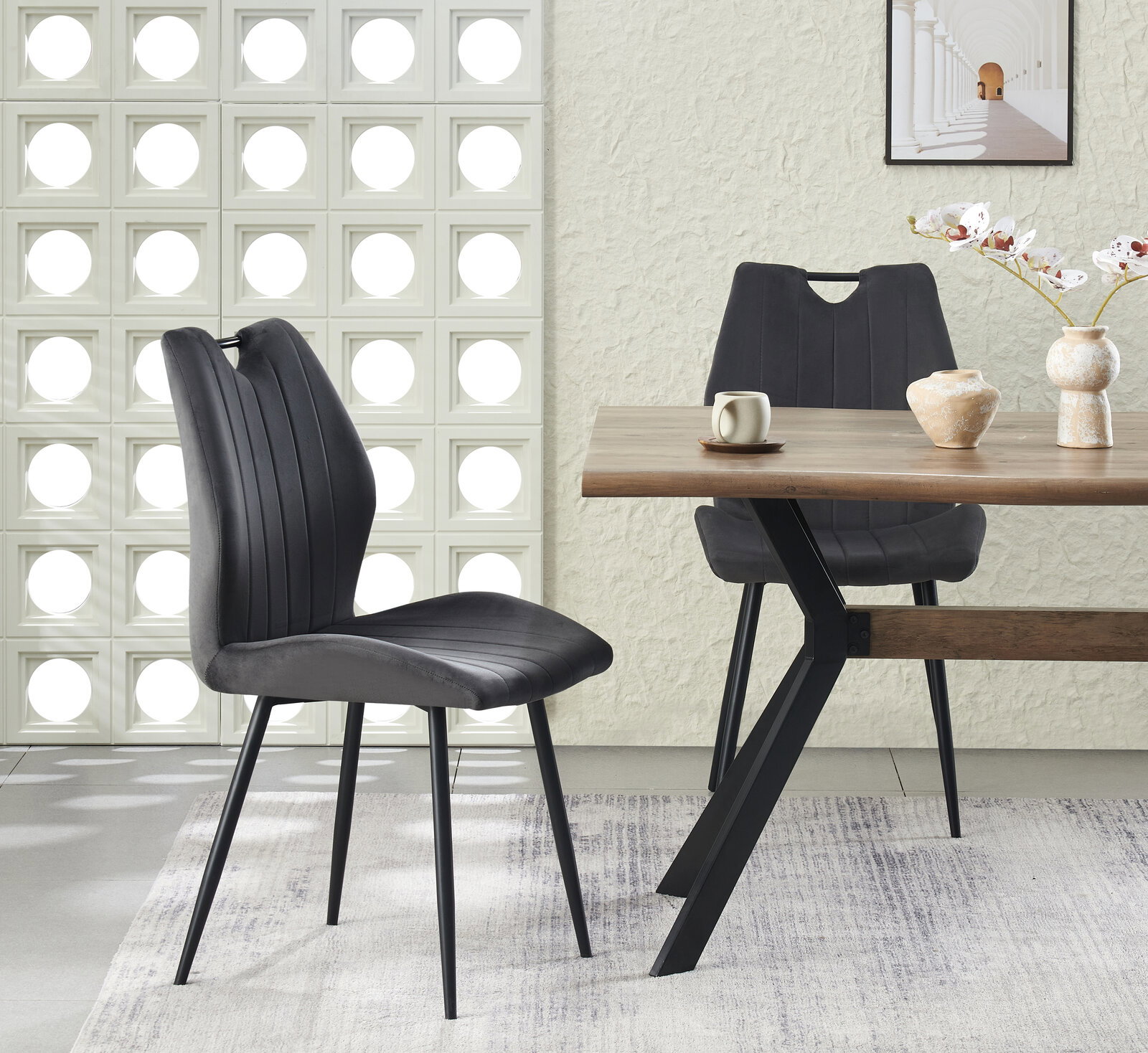 Moderner Esszimmerstuhl in Dunkelgrau mit vertikaler Steppung und schwarzen Metallbeinen am Holzesstisch, seitliche Perspektive im hellen Wohnambiente