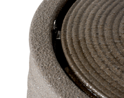 Nahaufnahme eines runden, geriffelten Objekts aus recyceltem Kunststoff, von oben betrachtet.