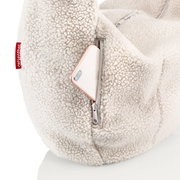 Nahaufnahme einer cremefarbenen Teddy-Fleece-Tasche mit Reißverschlussfach, aus dem ein Smartphone herausragt; Perspektive: seitliche Detailansicht.