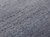 Nahaufnahme eines grauen Wollteppichs mit weicher, flauschiger Textur.
