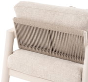 Achterkant van een loungestoel met een beige stoffen bekleding en een gevlochten rugleuning.