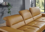 Cognacfarbenes Leder-Sofa mit verstellbaren Kopfstützen und gesteppter Sitzfläche im modernen Wohnzimmer, Perspektive: schräger Blick von vorne links (Nahaufnahme)