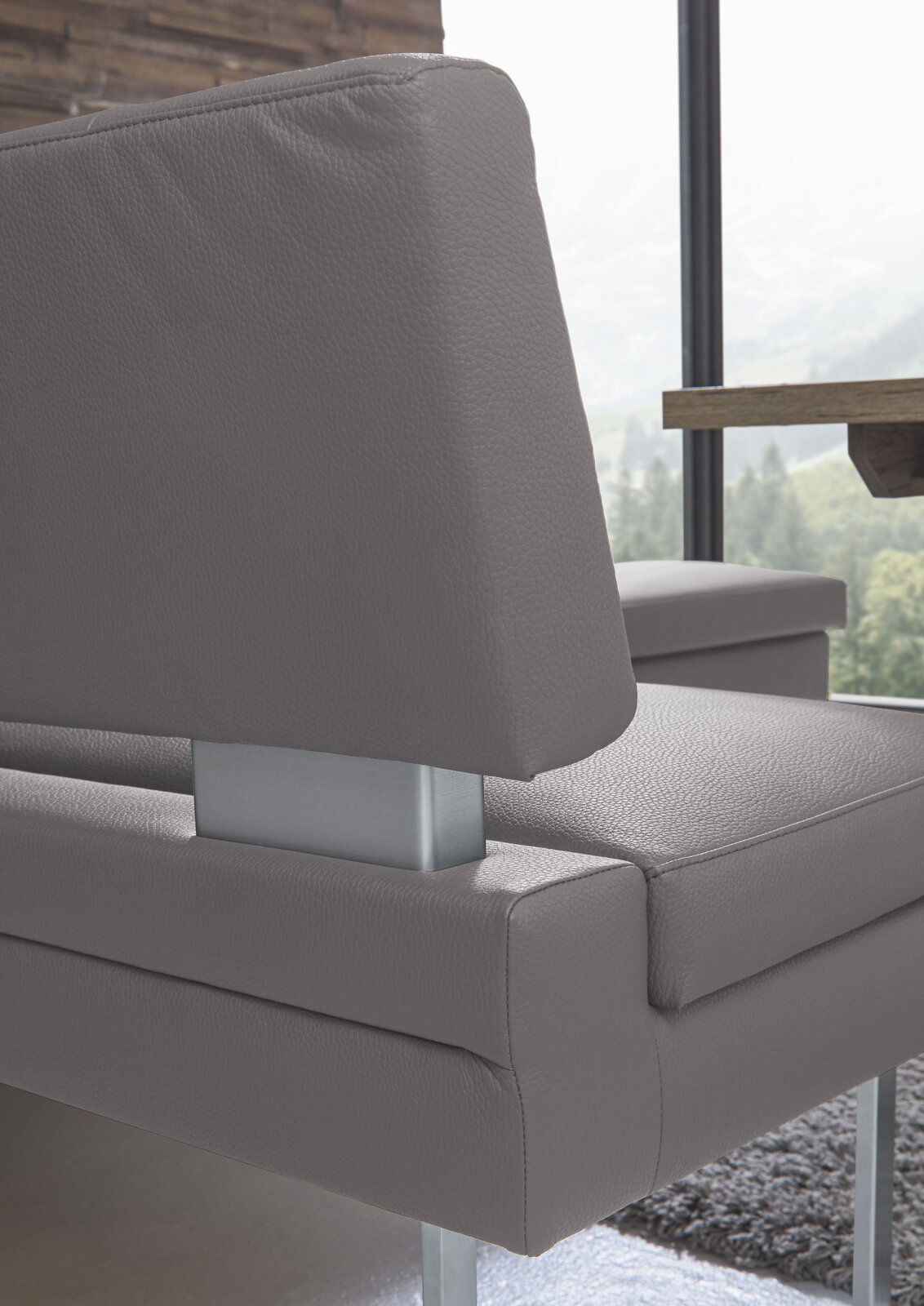 Nahaufnahme einer modernen grauen Eckbank mit Metallgestell, seitliche Perspektive.