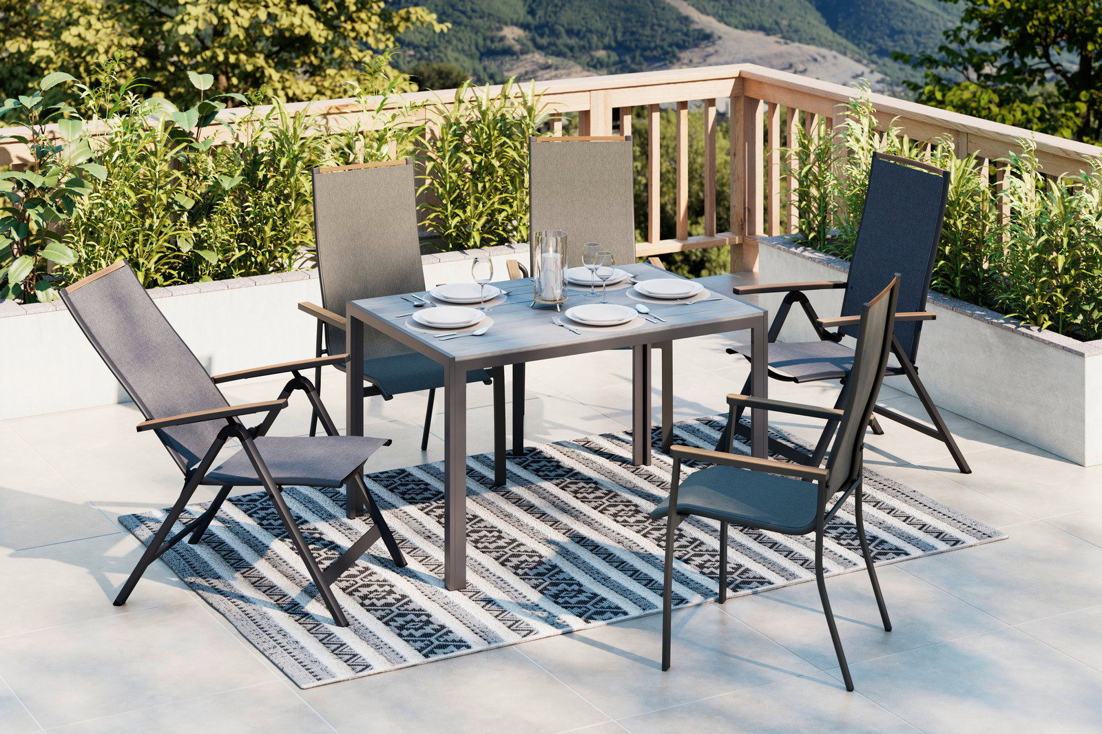 Moderner Gartentisch mit vier Stühlen auf einer Terrasse, umgeben von Pflanzen, mit Blick auf die Berge. Perspektive von schräg oben.