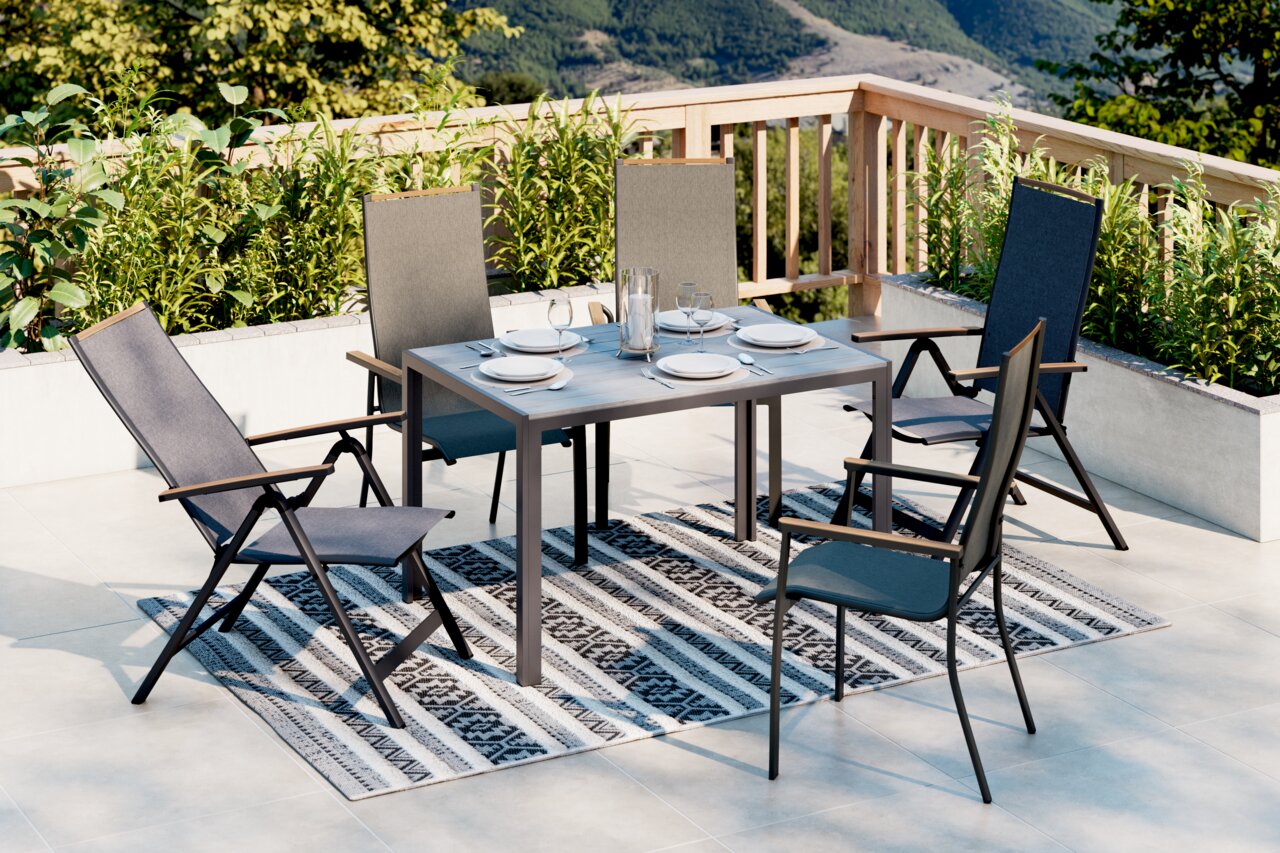 Ambia Garden Gartentisch VALENCIA Moderner Gartentisch mit vier Stühlen auf einer Terrasse, umgeben von Pflanzen, mit Blick auf die Berge. Perspektive von schräg oben.