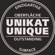 Rundes Siegel mit der Aufschrift 'Einzigartige Oberfläche, Unikat, Outstanding Surface' in Schwarz-Weiß, frontal betrachtet.