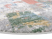 Nahaufnahme eines bunten Frisé-Teppichs mit abstraktem Muster in verschiedenen Farben wie Grau, Grün, Gelb und Rot, aus seitlicher Perspektive.