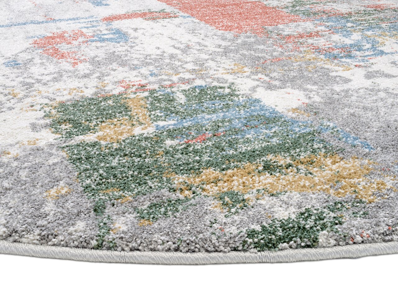 Nahaufnahme eines bunten Frisé-Teppichs mit abstraktem Muster in verschiedenen Farben wie Grau, Grün, Gelb und Rot, aus seitlicher Perspektive.