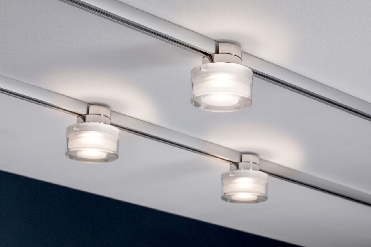 Drei moderne Schienenspots der Marke Paulmann Topa URAIL, montiert an einer Decke, aus seitlicher Perspektive fotografiert.
