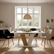 Heller Essbereich mit modernem Esstisch in Weiß und Holz mit V-förmigem Gestell, umgeben von vier gepolsterten Stühlen und einer geflochtenen Pendelleuchte; Frontalansicht auf Tisch und Sitzgruppe vor großem Fenster.