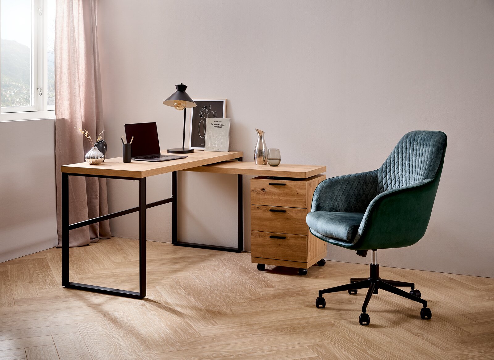 Moderner Drehstuhl in grünem Samt mit Rautensteppung, seitliche Perspektive, neben einem Schreibtisch mit Holzplatte und schwarzem Metallgestell in einem stilvollen Büro.