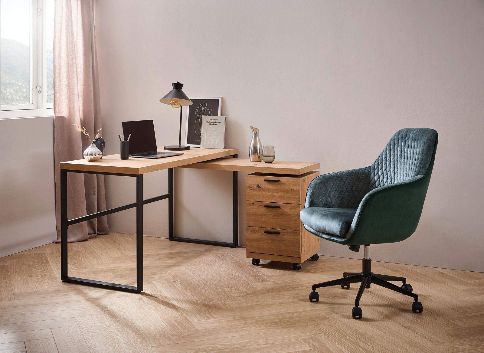 Moderner Drehstuhl in grünem Samt mit Rautensteppung, seitliche Perspektive, neben einem Schreibtisch mit Holzplatte und schwarzem Metallgestell in einem stilvollen Büro.