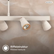 Detailaufnahme einer weißen Deckenleuchte mit drei geriffelten Spot-Schirmen und Holzakzenten, leicht von unten in Frontalansicht fotografiert.