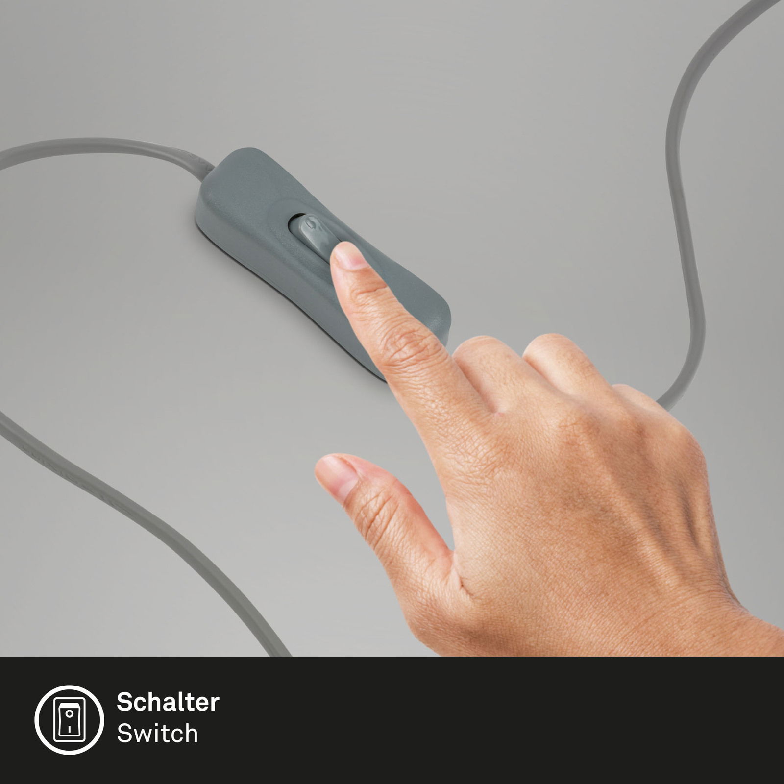 Nahaufnahme eines Fingers, der einen grauen Kippschalter auf einem Kabel betätigt, perspektivisch von oben.