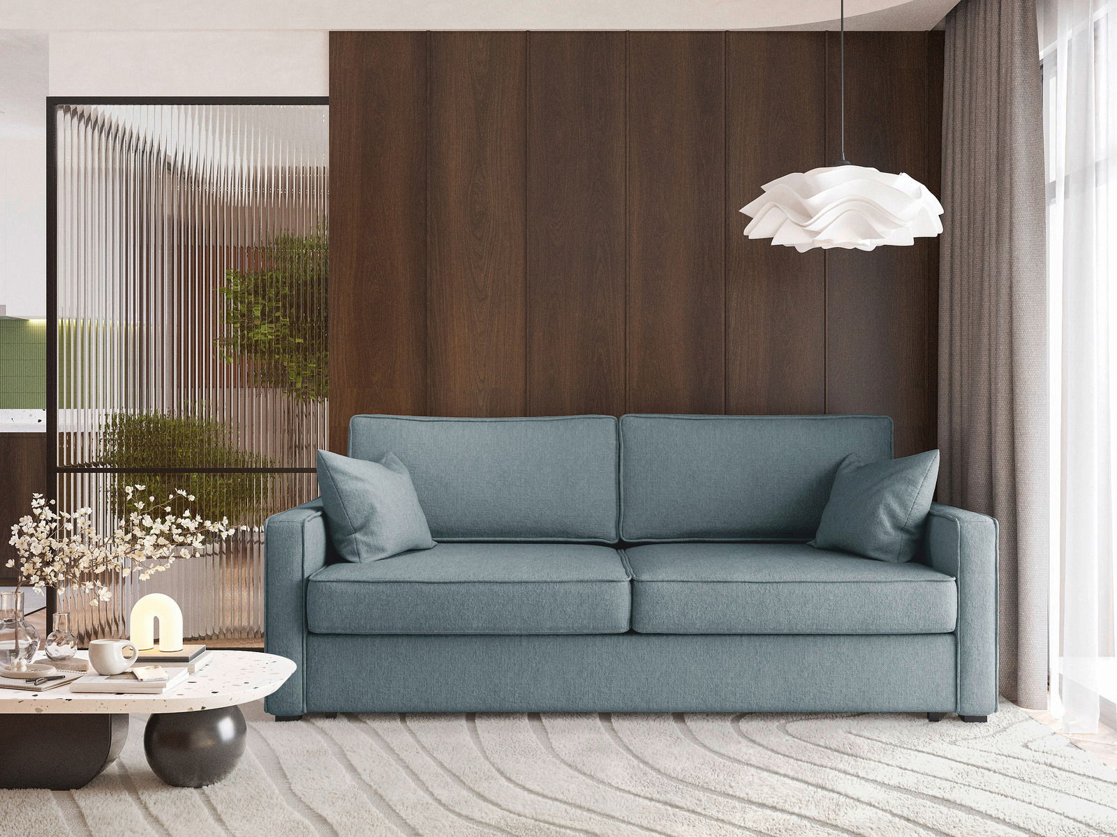 Modernes Funktionssofa in blauer Farbe, frontal fotografiert, mit zwei Kissen, vor einer Holzwand und neben einem Couchtisch mit Dekorationen.