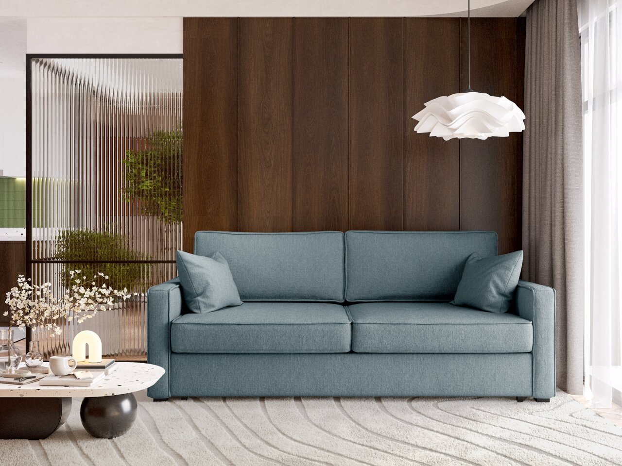 Modernes Funktionssofa in blauer Farbe, frontal fotografiert, mit zwei Kissen, vor einer Holzwand und neben einem Couchtisch mit Dekorationen.