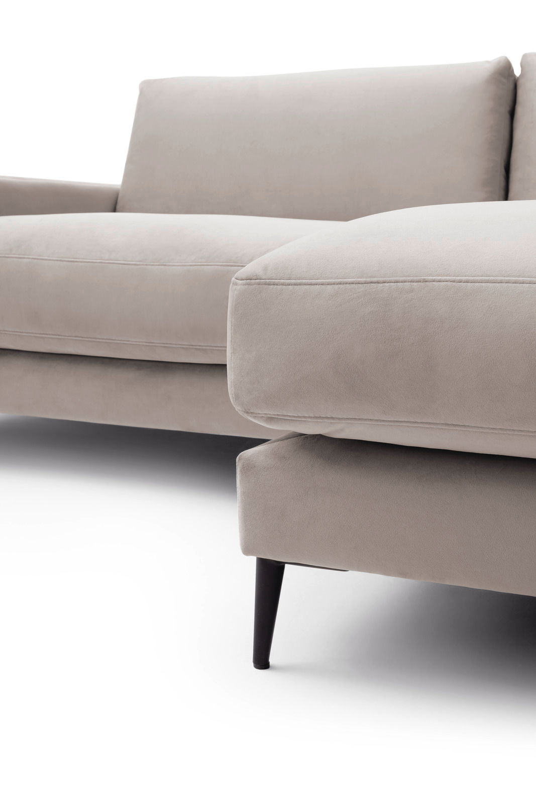 Nahaufnahme einer beigen Longchairkombination mit schwarzem Bein, seitliche Perspektive.