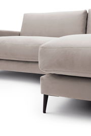 Nahaufnahme einer beigen Longchairkombination mit schwarzem Bein, seitliche Perspektive.