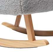 Nahaufnahme der Holzbeine eines Schaukelsessels mit grauem Stoffbezug, seitliche Perspektive