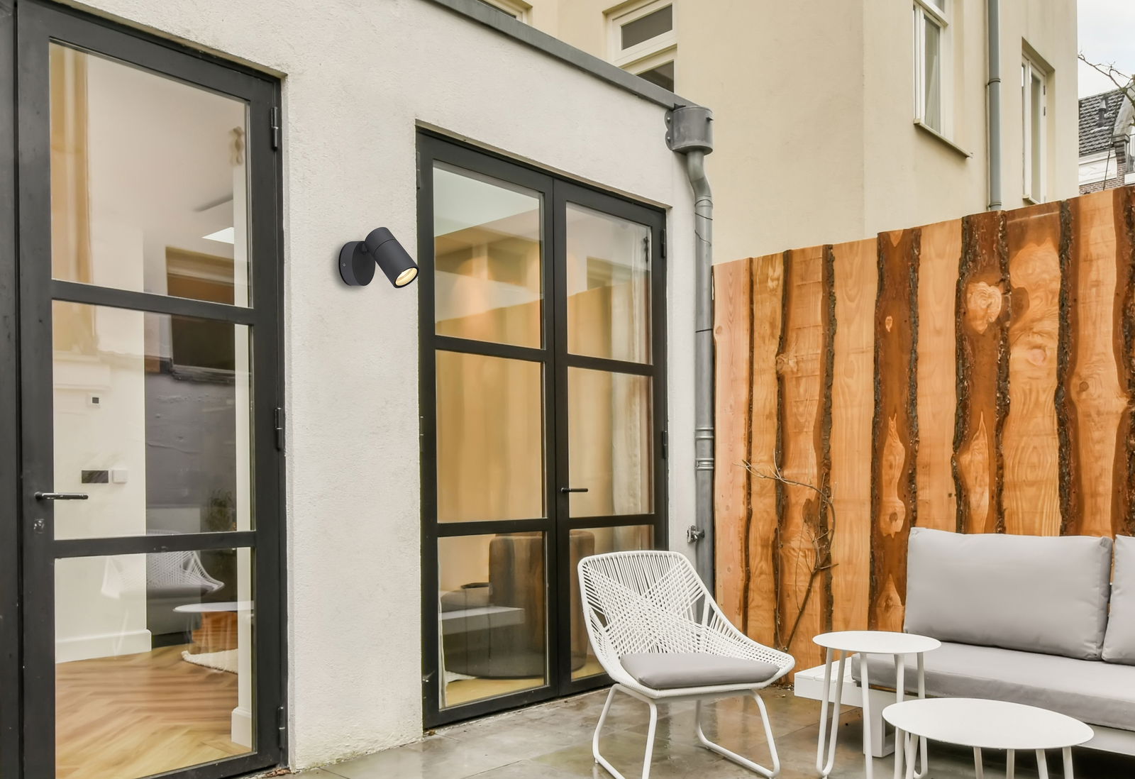 Moderne schwarze Außenwandleuchte an einer Hauswand, seitliche Perspektive.